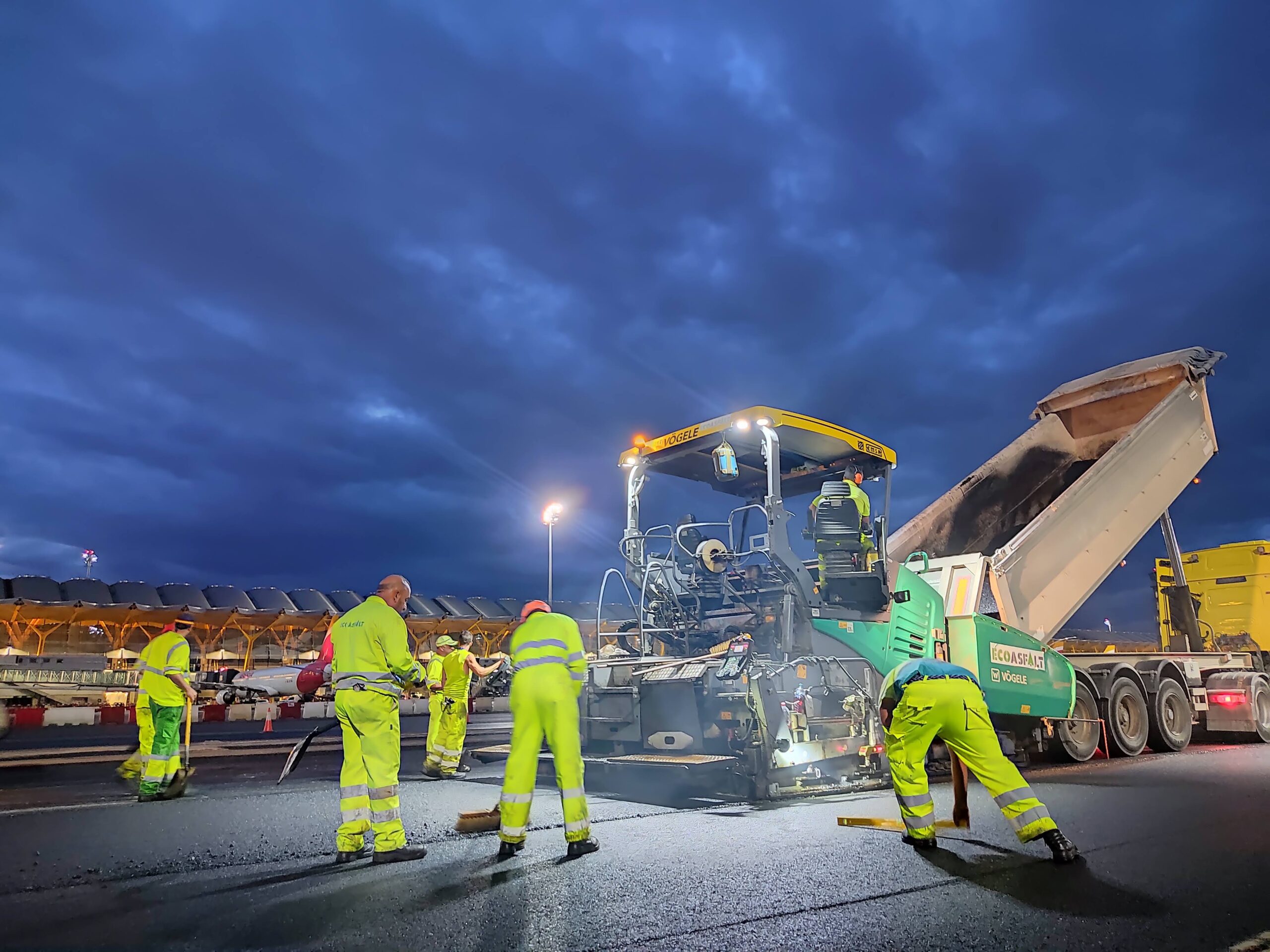 Técnicos midiendo espesores y controlando la temperatura del asfalto en obra aeroportuaria