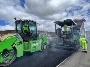 Extendedora y rodillos compactando asfalto en caliente sobre una carretera